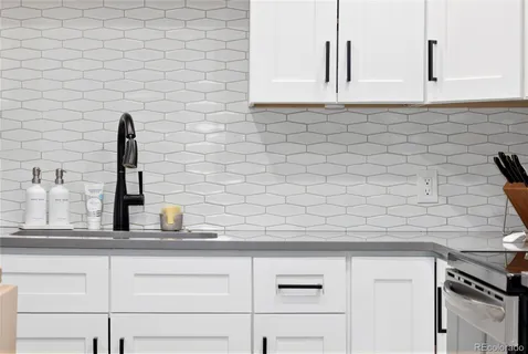 a kitchen with a sink a stove a refrigerator and dining table with wooden floor