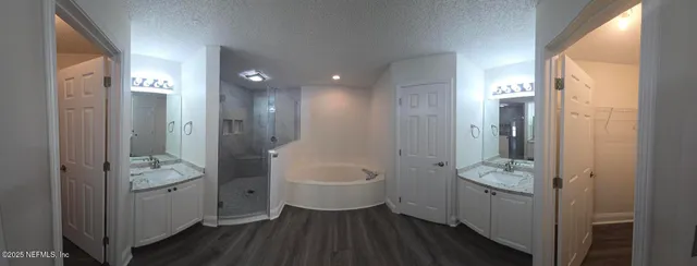 an empty room with wooden floor closet and fan