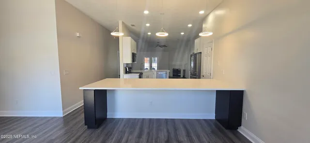a room with kitchen island a wooden floor and a sink