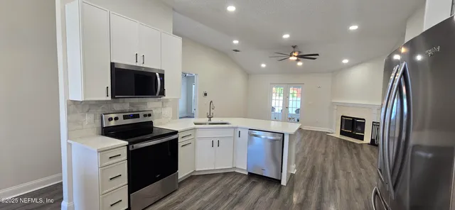 a kitchen with kitchen island white cabinets and stainless steel appliances