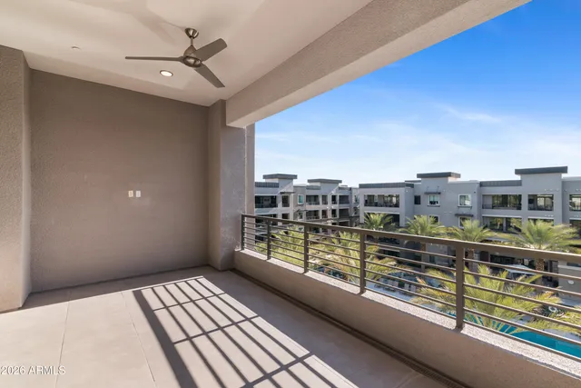 a view of a hallway with wooden floor and a large mirror