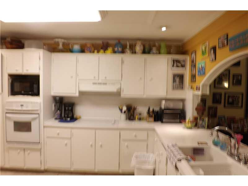 16137 Laurel Drive, Unit 32 Weston, FL 33326 - Photo 3 of 9 a kitchen with refrigerator and cabinets