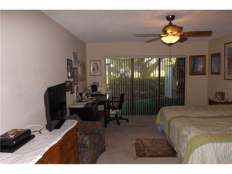 16137 Laurel Drive, Unit 32 Weston, FL 33326 - Photo 4 of 9 a bedroom with a bed and a chandelier