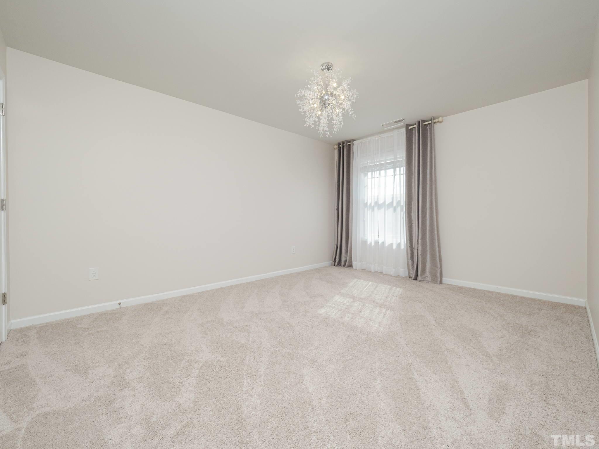 7435 Randshire Way Raleigh, NC 27616 - Photo 11 of 25 a view of an empty room with a chandelier fan