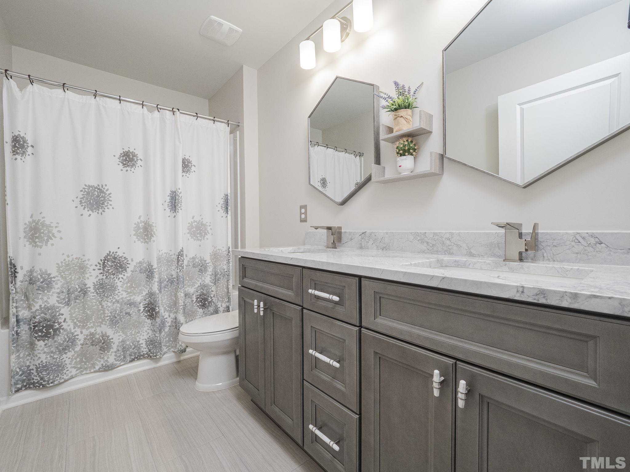 7435 Randshire Way Raleigh, NC 27616 - Photo 18 of 25 a bathroom with a double vanity sink mirror double and shower