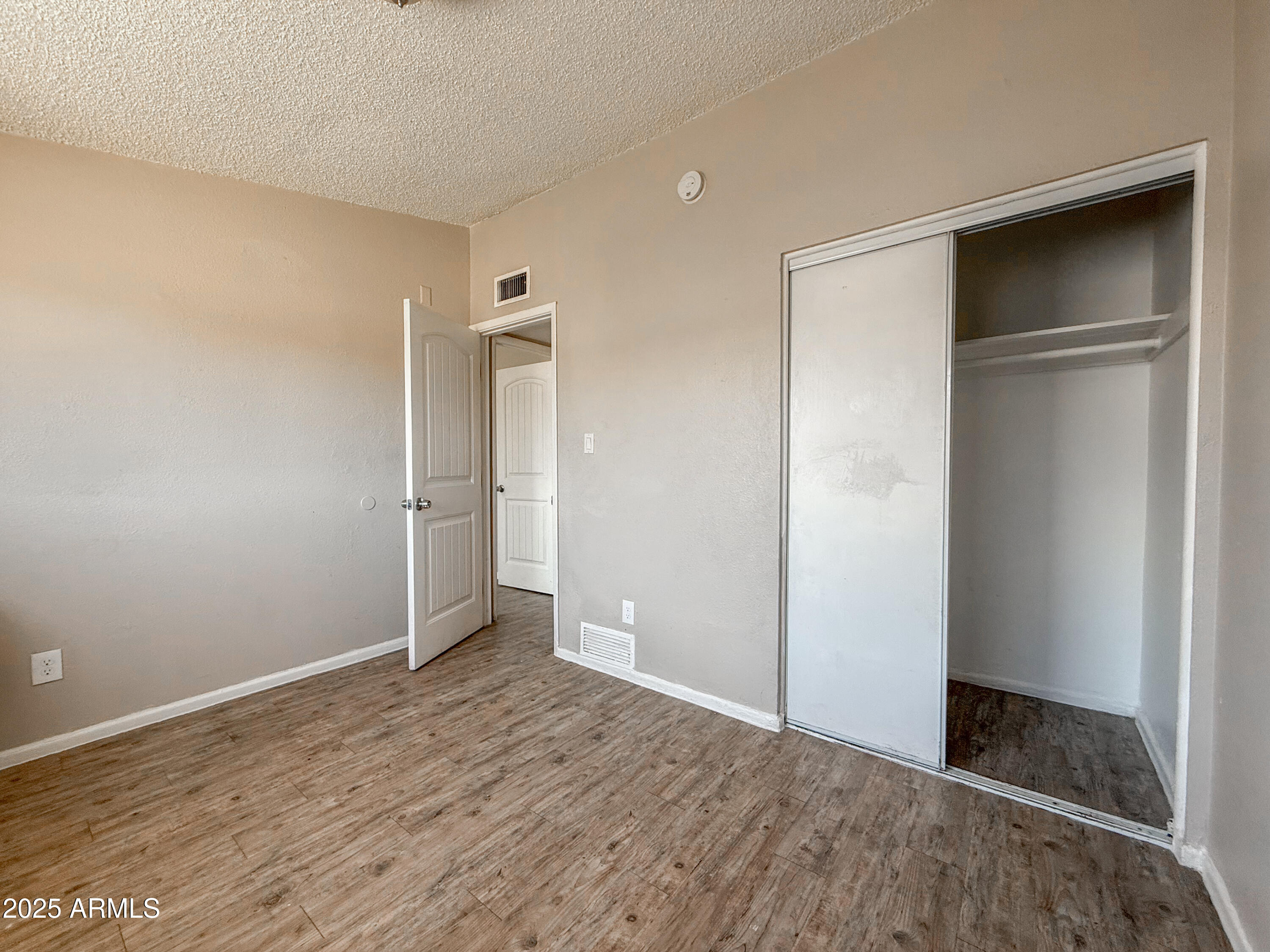 2139 West Devonshire Avenue, Unit 3 Phoenix, AZ 85015 - Photo 13 of 13 a view of an empty room with wooden floor & closet
