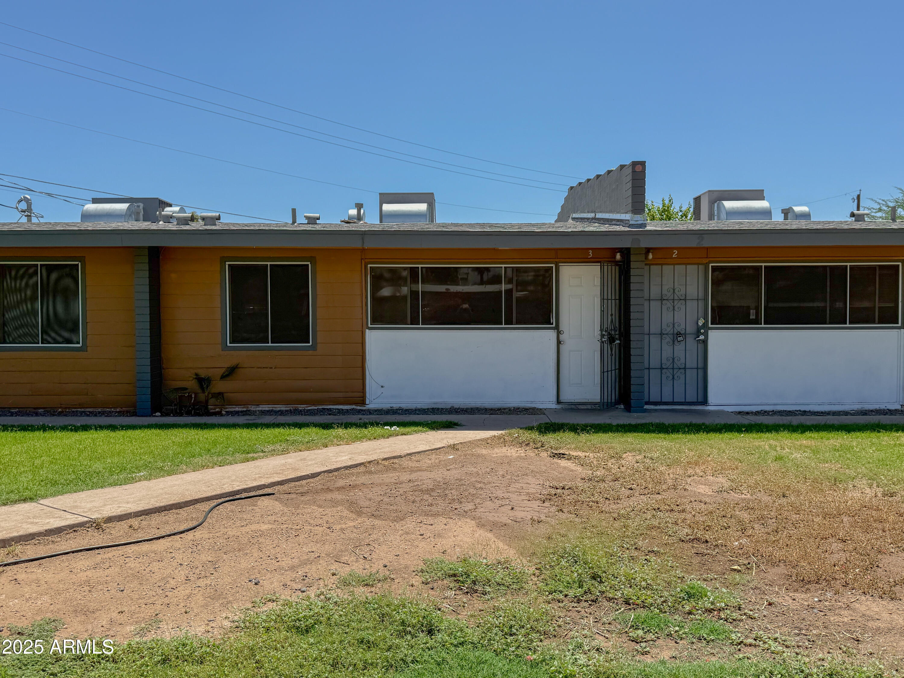 2139 West Devonshire Avenue, Unit 3 Phoenix, AZ 85015 - Photo 2 of 13 a front view of a house with a yard and a garage
