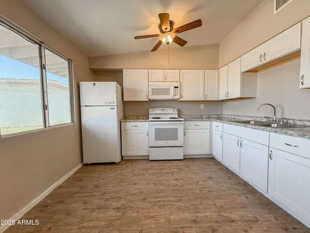 a kitchen with a refrigerator a sink and cabinets