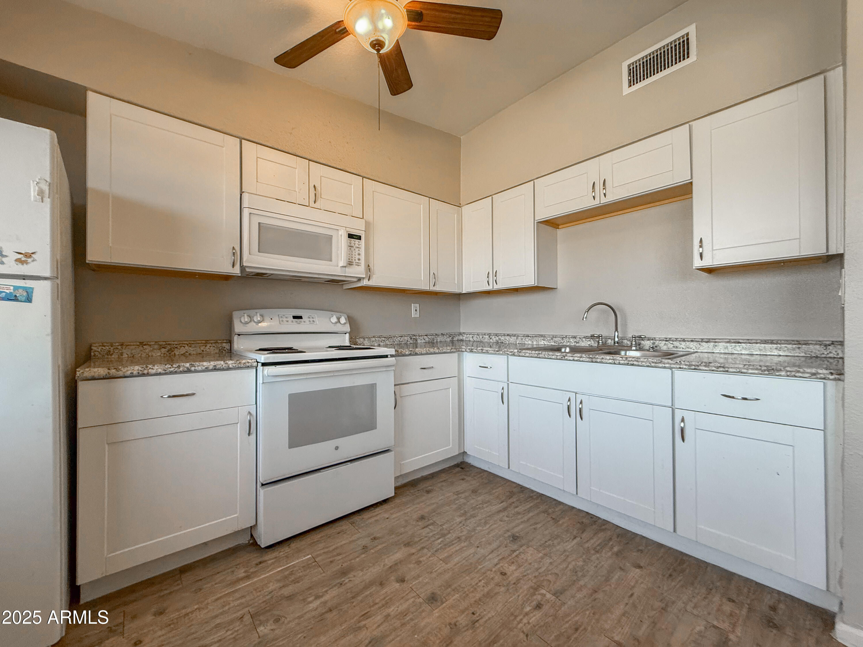 2139 West Devonshire Avenue, Unit 3 Phoenix, AZ 85015 - Photo 7 of 13 a kitchen with granite countertop white cabinets and white appliances