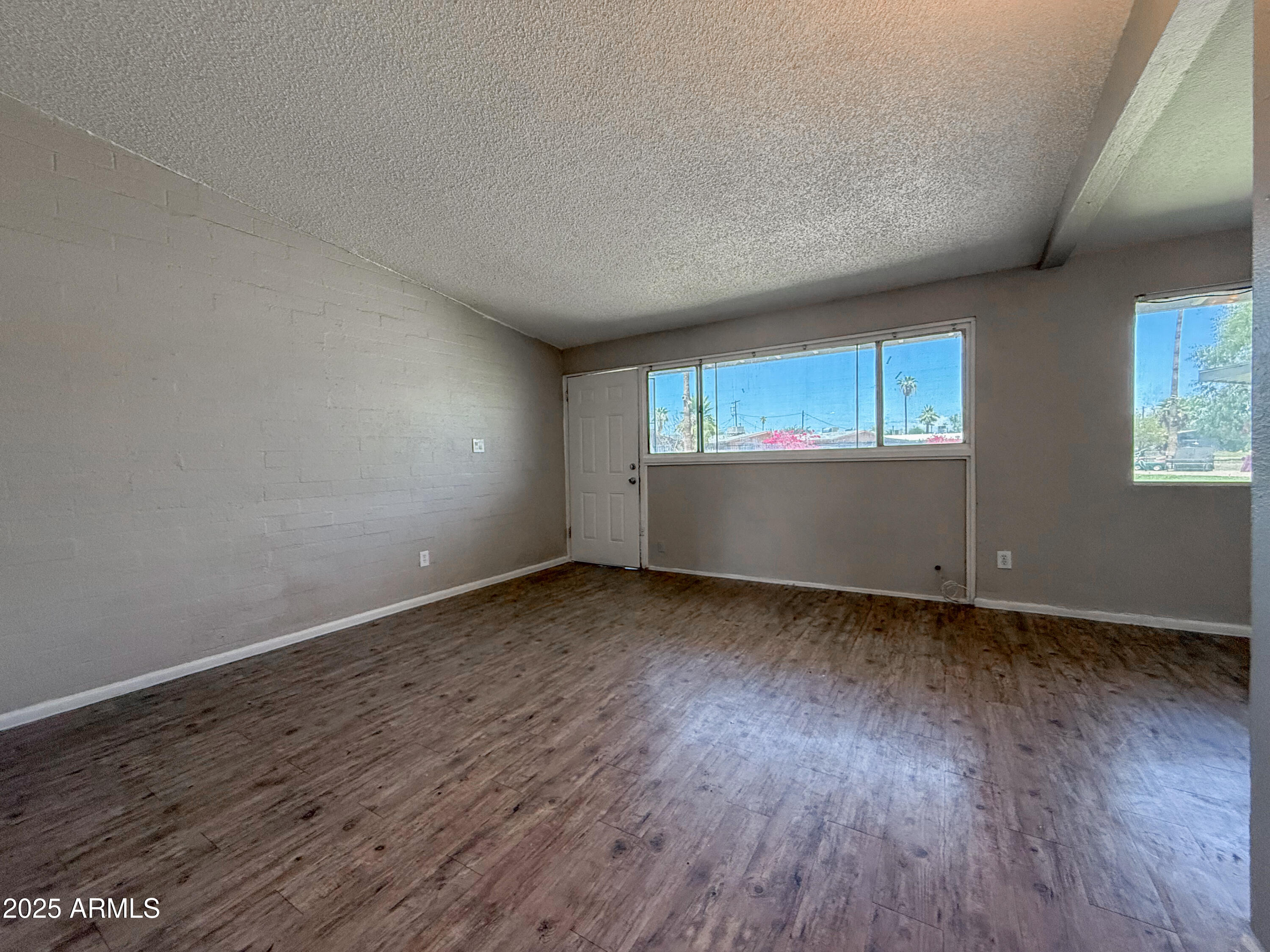 2139 West Devonshire Avenue, Unit 3 Phoenix, AZ 85015 - Photo 8 of 13 an empty room with wooden floor and windows