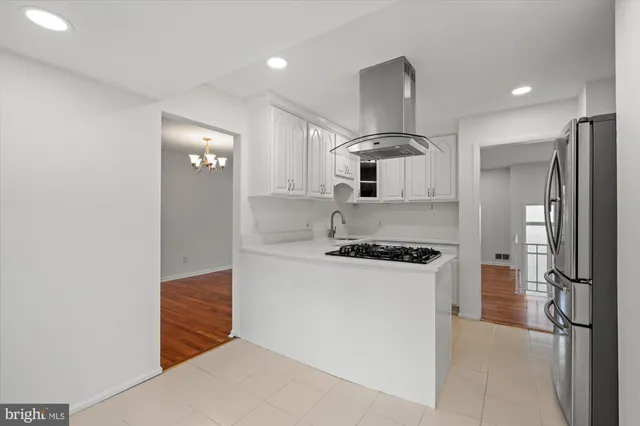 a kitchen with stainless steel appliances white cabinets and a stove top oven