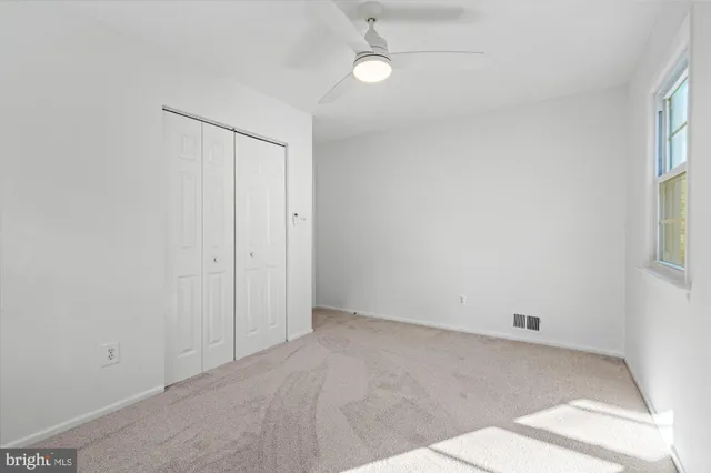 an empty room with windows and closet