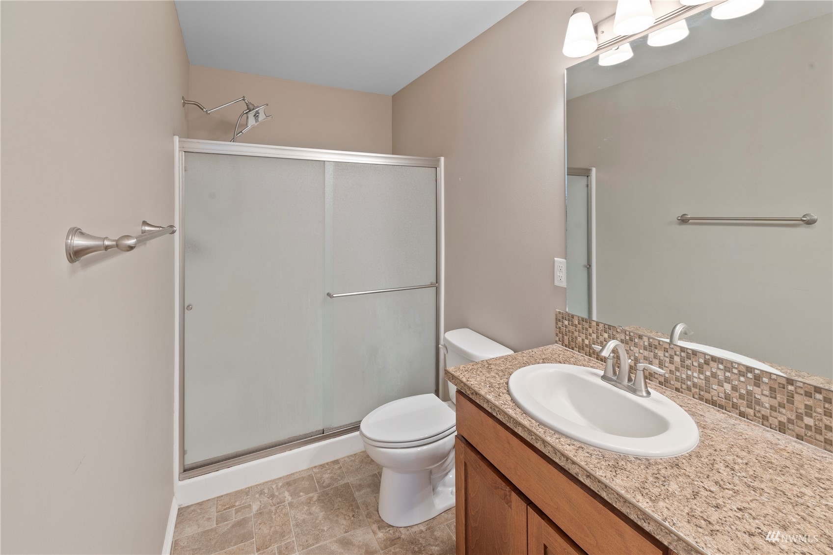 5909 Coolidge Road Yakima, WA 98903 - Photo 16 of 27 a bathroom with a granite countertop sink toilet a mirror and shower
