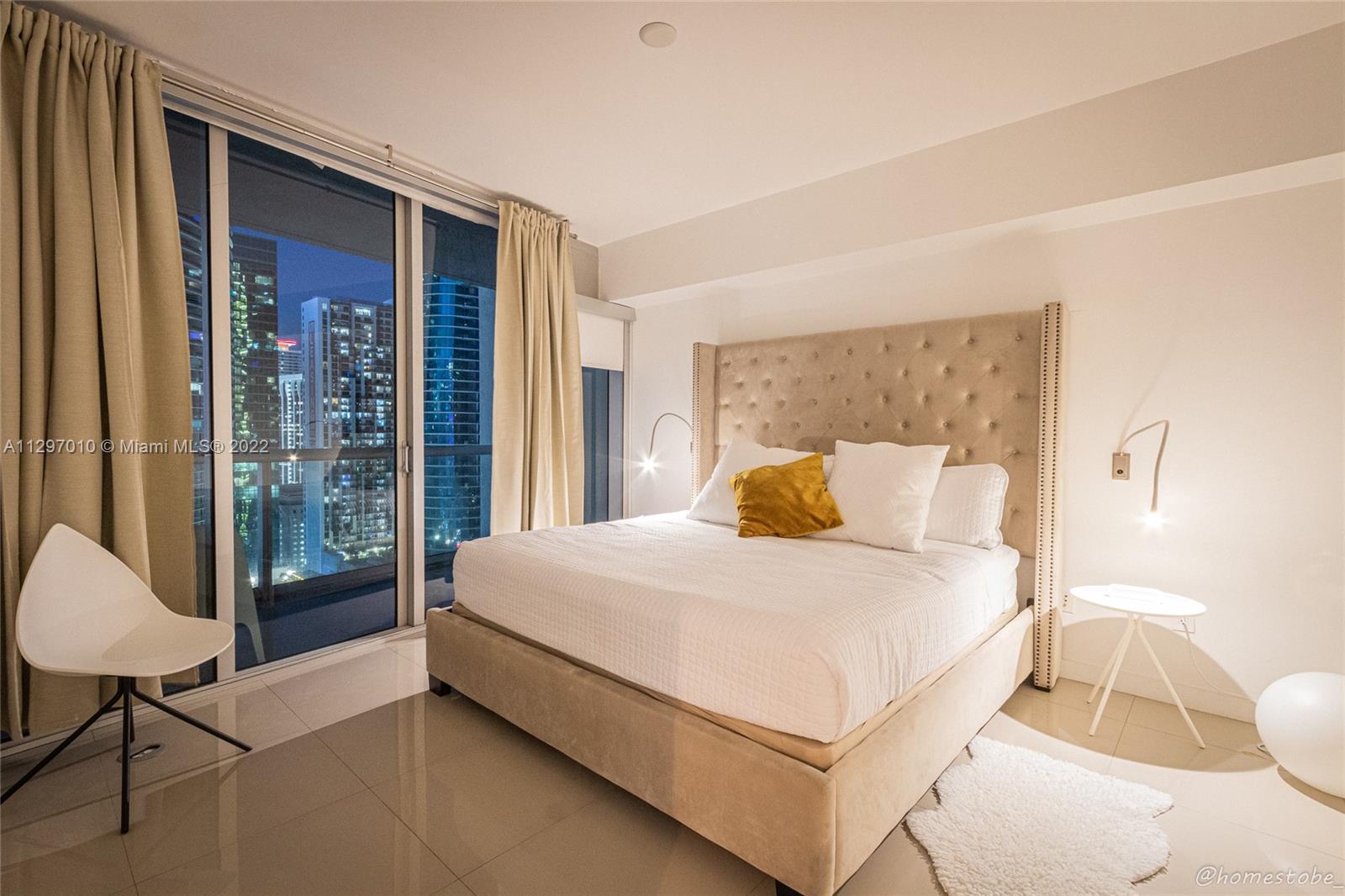 485 Brickell Avenue, Unit 3003 Miami, FL 33131 - Photo 11 of 17 a bedroom with a bed lamp and a large window