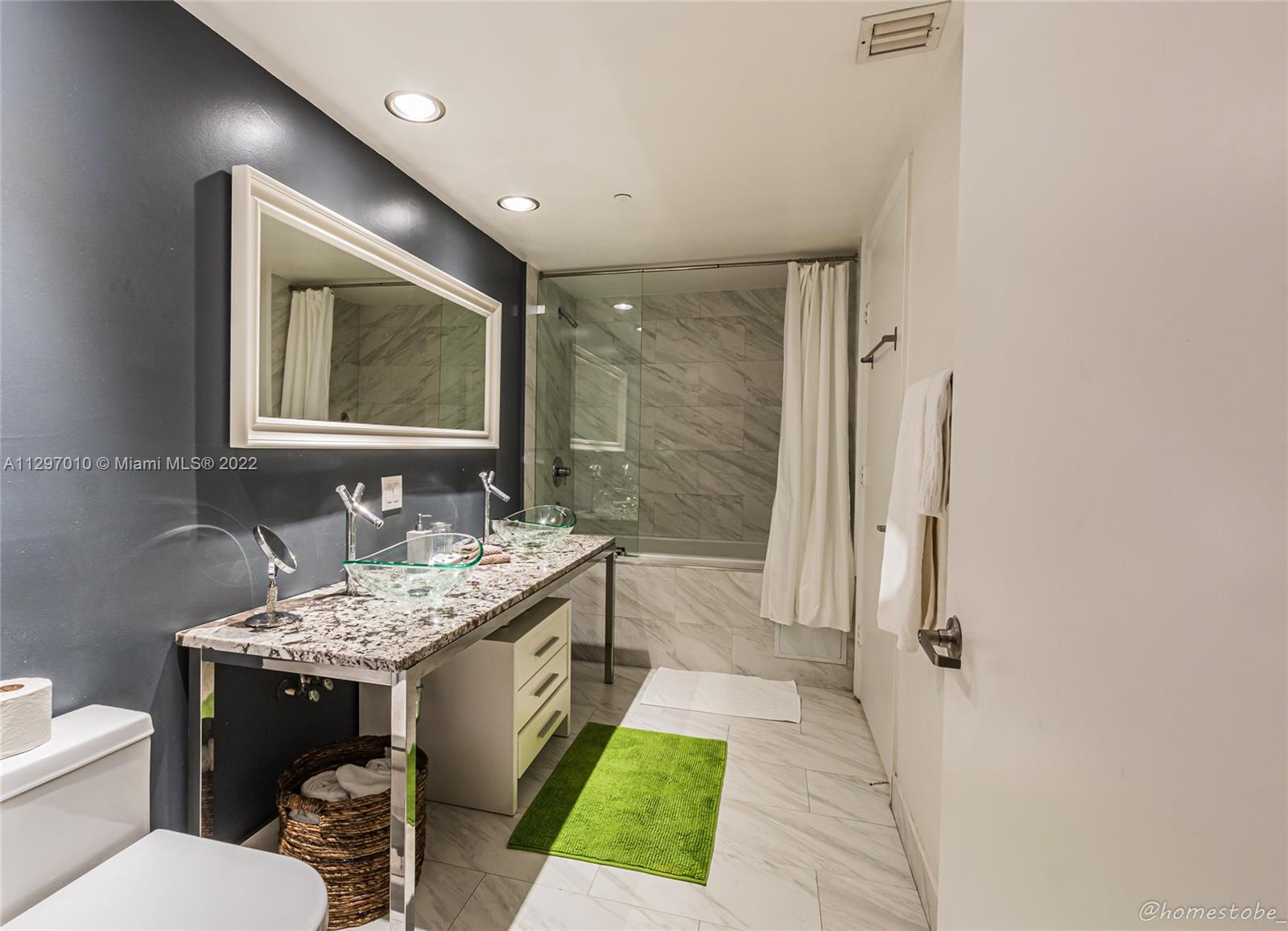 485 Brickell Avenue, Unit 3003 Miami, FL 33131 - Photo 12 of 17 a bathroom with a toilet sink and mirror