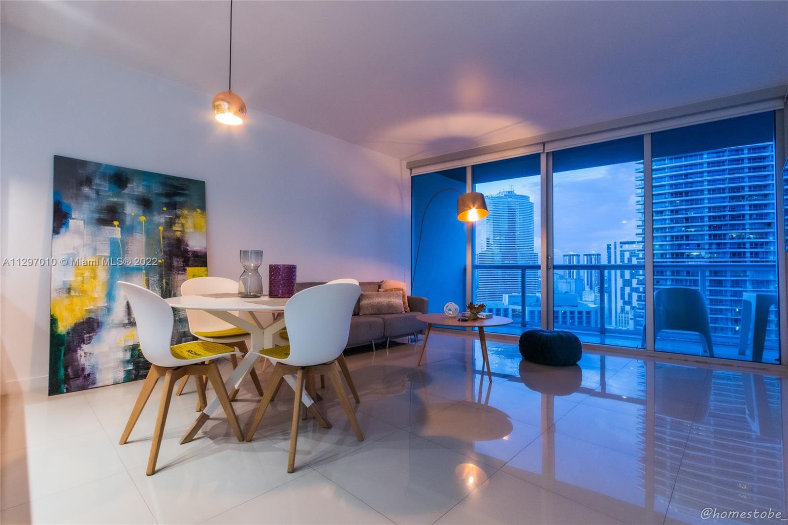 485 Brickell Avenue, Unit 3003 Miami, FL 33131 - Photo 6 of 17 a view of a dining room with furniture a chandelier and wooden floor