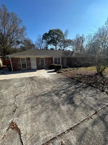 a front view of house with yard and trees in the background
