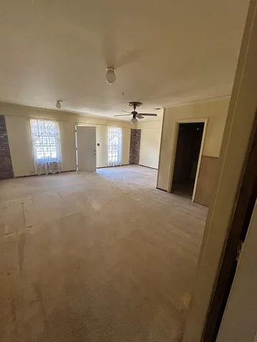 an empty room with windows and fireplace