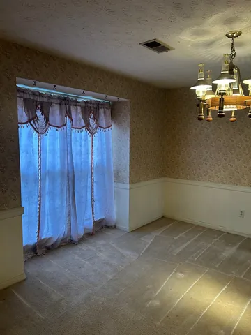 a view of a room with a water heater and wooden cabinet