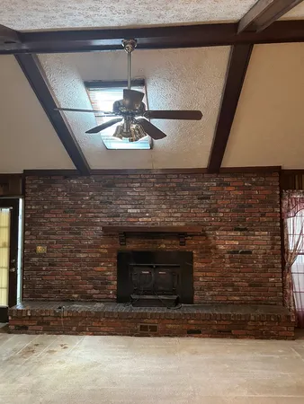 an empty room with windows and fireplace