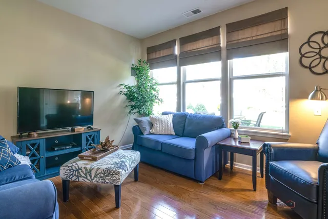 a living room with furniture a flat screen tv and a large window