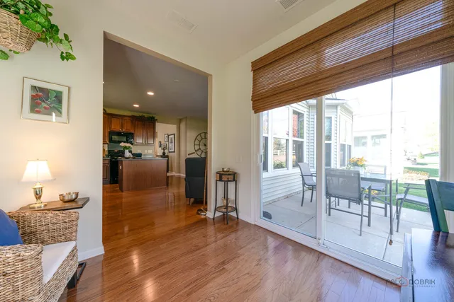 a living room with furniture large windows and wooden floor