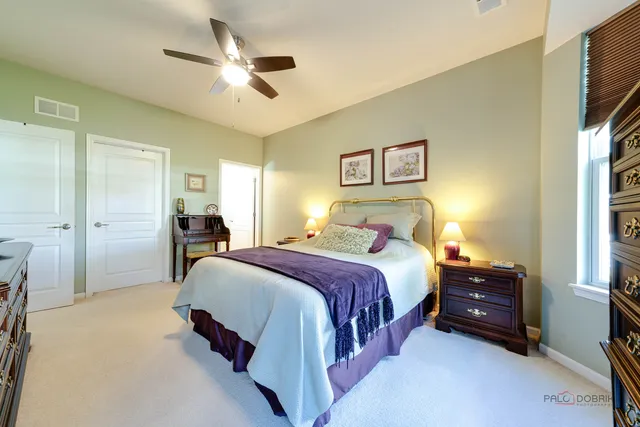 a spacious bedroom with a bed and a chandelier