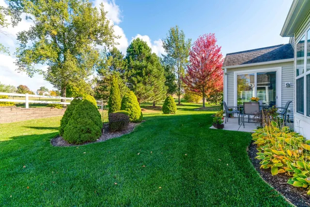 a view of a garden with lawn chairs under an umbrella