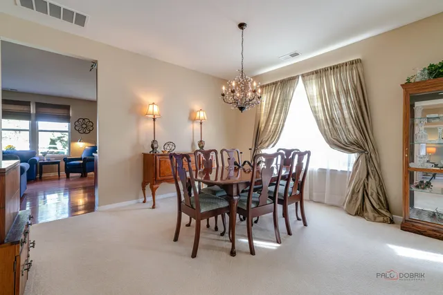 a view of a dining room with furniture and chandelier