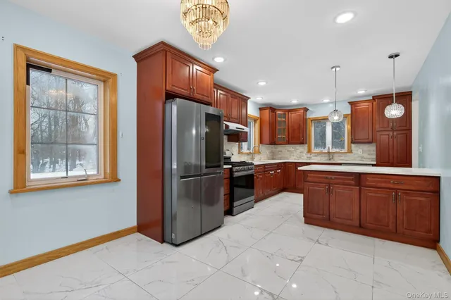 a kitchen with stainless steel appliances granite countertop a refrigerator a sink a stove a microwave and island