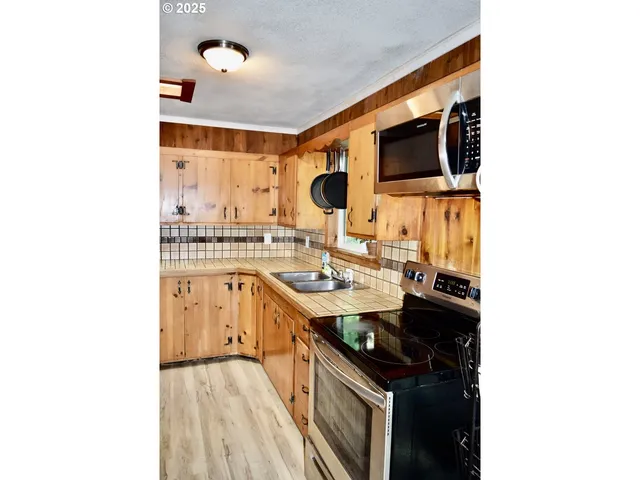 a kitchen with stainless steel appliances a stove and a microwave