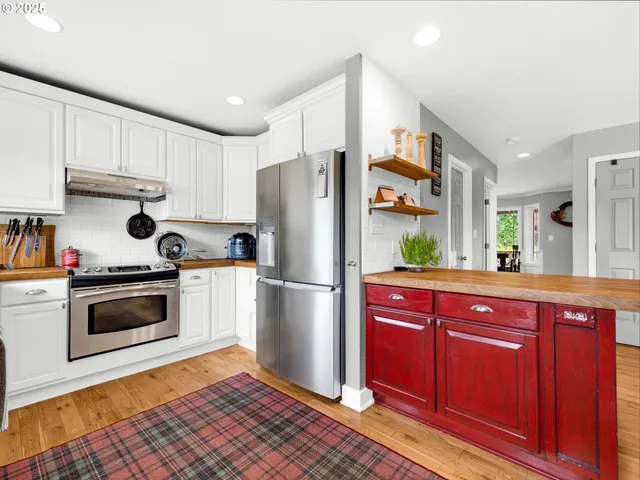 a kitchen with stainless steel appliances granite countertop a refrigerator stove and sink