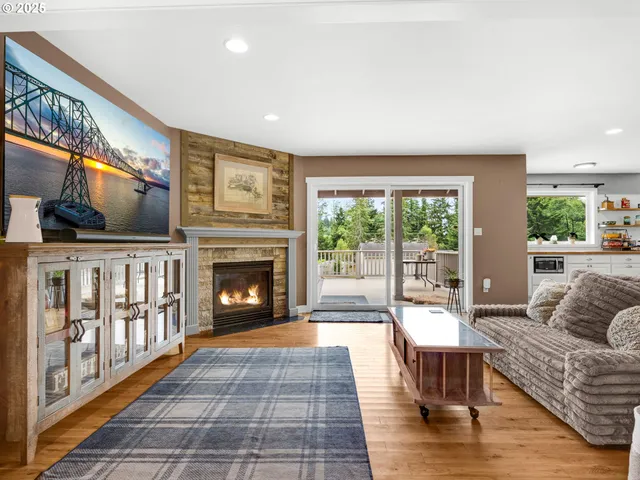 a living room with furniture a fireplace and a floor to ceiling window