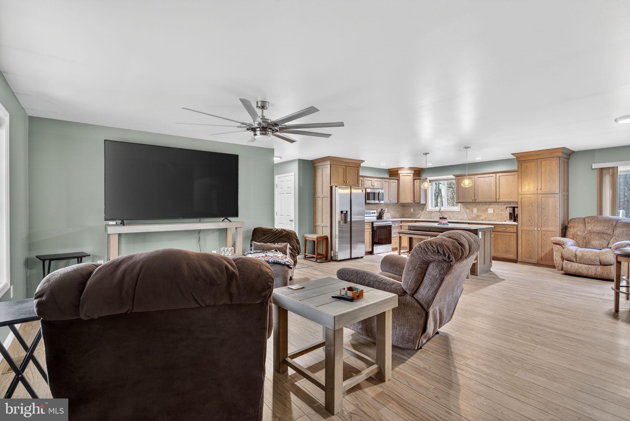 849 Sugar Run Road Millerstown, PA 17062 - Photo 4 of 34 a living room with furniture a flat screen tv and kitchen view