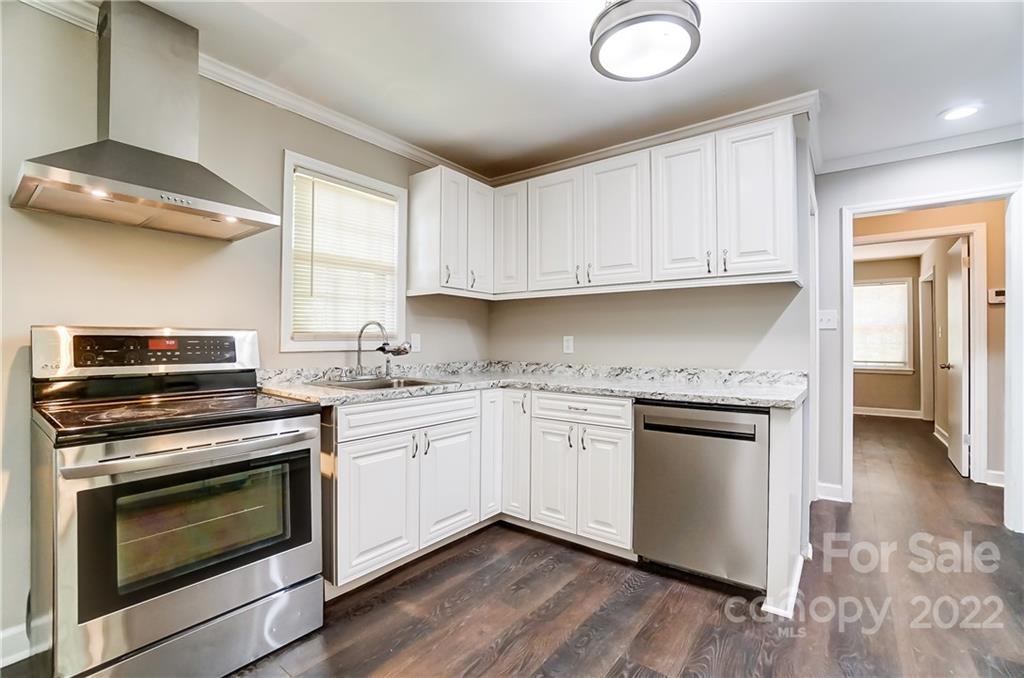 502 Plantation Road Lancaster, SC 29720 - Photo 13 of 44 a kitchen with granite countertop a stove sink and cabinets