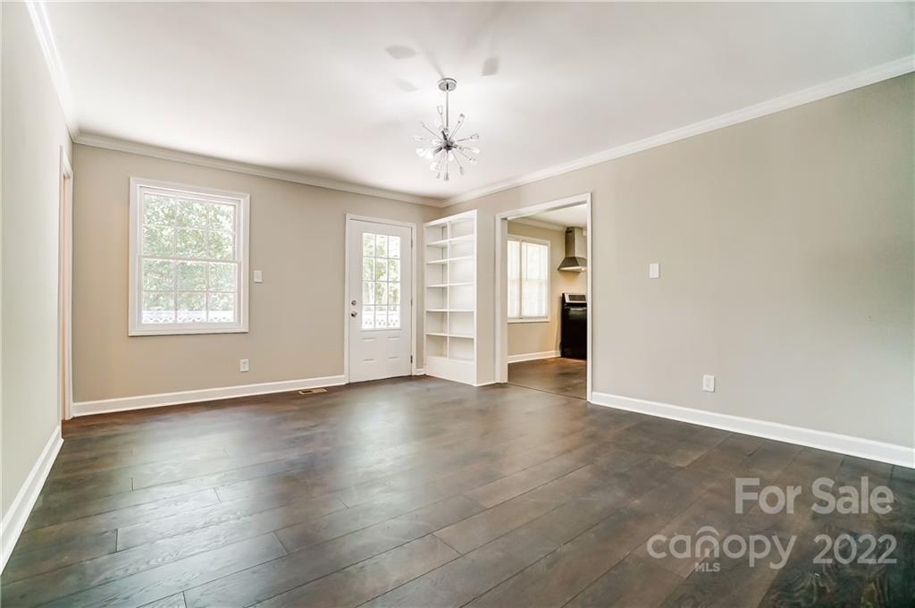 502 Plantation Road Lancaster, SC 29720 - Photo 17 of 44 an empty room with wooden floor chandelier and windows