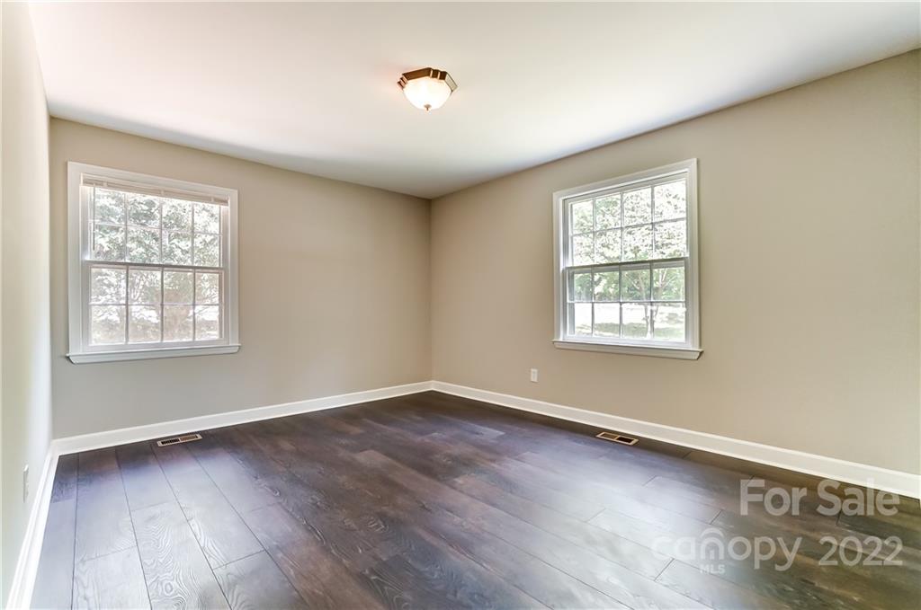 502 Plantation Road Lancaster, SC 29720 - Photo 21 of 44 an empty room with wooden floor and windows