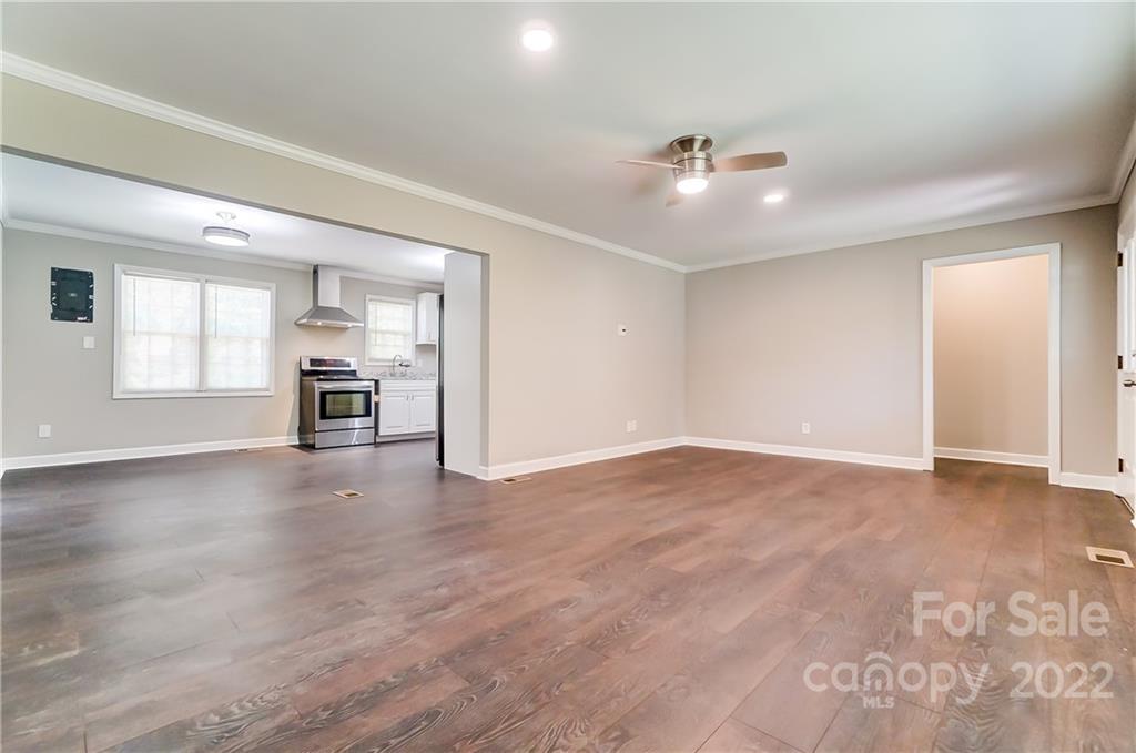 502 Plantation Road Lancaster, SC 29720 - Photo 7 of 44 an empty room with chandelier fan and windows