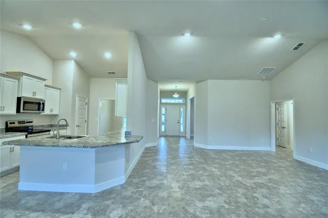 a kitchen with kitchen island granite countertop a sink a stove and cabinets