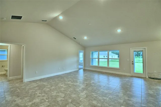 a view of kitchen and kitchen with granite countertop cabinets