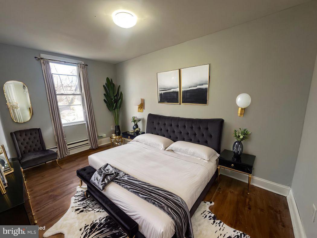 609 North Wilton Street Philadelphia, PA 19131 - Photo 5 of 15 a bedroom with a bed a mirror and furniture