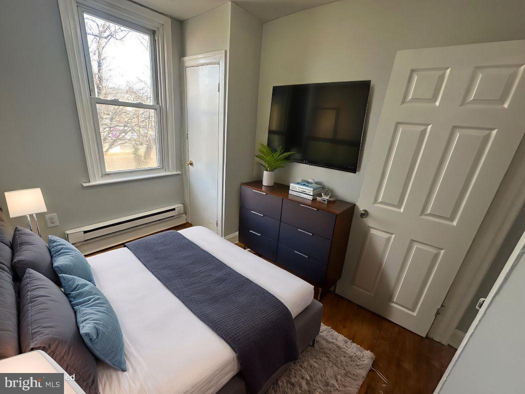 609 North Wilton Street Philadelphia, PA 19131 - Photo 7 of 15 a bedroom with a bed television with the wooden floor and a window