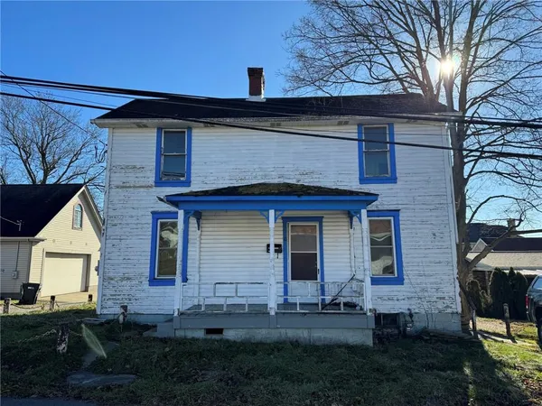 a front view of a house with a garden and yard