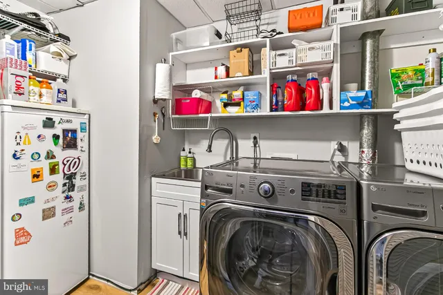 a utility room with fridge dryer and washer