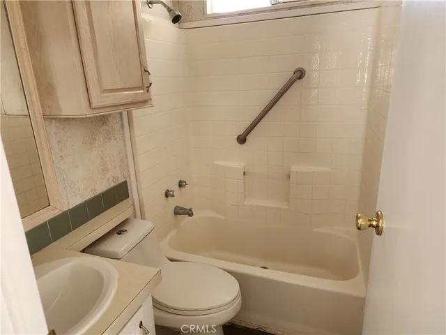 a white toilet sitting next to a bath tub