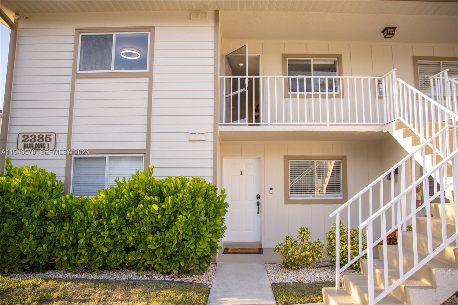 2385 Naples Trace Circle, Unit 5 Naples, FL 34109 - Photo 2 of 13 front view of a house with a yard