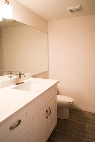 a bathroom with a sink a toilet and mirror