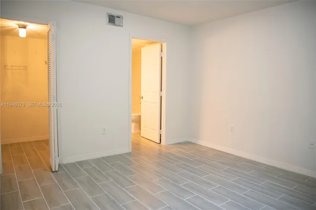 an empty room with wooden floor and a window