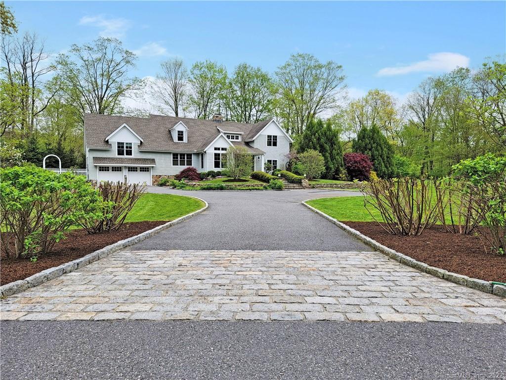 front view of a house with a yard and potted plants