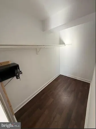 a view of a room with wooden floor and cabinets